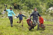Die Familie Wedekind mit Melanie (Katrin Ritt, l.), Philipp (Vincent Mauz, M.) und Stefan (Patrick Back, r.) eilt durch das Unwetter zu den gerade eintreffenden Fahrzeugen der Bergwacht.