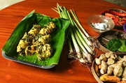 Timbungan stammt aus einer Zeit, in der auf Bali noch ohne T&ouml;pfe und Pfannen gekocht wurde: H&uuml;hnerfleisch wird mit einem pikant gew&uuml;rzten Teig und Moringa-Bl&auml;ttern vermengt, in Bambusstangen gef&uuml;llt und schlie&szlig;lich am Feuer gegart.