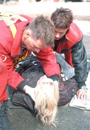 Ralf (Wolfgang Krewe, li.) und Biggi (Sabine Petzl, re.) verarzten die lebensgef&auml;hrlich verletzte Kollegin Dr. Gabriele Kollmann (Anja Freese, lieg.).