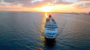 Kreuzfahrtschiff mit Sonnenuntergang.