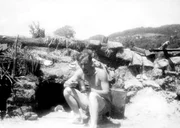 Werner Sch&uuml;ssler vor einem Erdloch, das er sich als Witterungsschutz im Kriegsgefangenenlager gegraben hat.