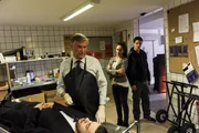 Der Bestatter Tibor Heckmann (Jochen Busse, 2.v.l.) l&auml;sst sich durch die Befragung von Selma Kirsch (Yve Burbach, 2.v.r.) und Rico Sander (Benjamin Strecker, r.) nicht von seiner Arbeit an einem Verstorbenen (Komparse, l.) ablenken. Er steht den Ermittlern Rede und Antwort.