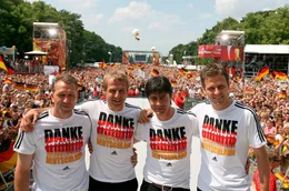 Torwart-Trainer Andreas Koepke (l-r), der damalige Bundestrainer J&uuml;rgen Klinsmann, sein damaliger Co-Trainer Joachim L&ouml;w und Team-Manager Oliver Bierhoff stehen auf der Fan-Meile am Brandenburger Tor zusammen.