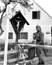 &Ouml;sterreich 1945: ein &bdquo;Marterl&ldquo; dient zur Verst&auml;rkung eines Schlagbaumes in der N&auml;he von Graz, vor dem ein russischer Soldat patrouilliert.