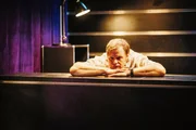 Frank (Michael A. Grimm) gelangweilt bei der Arbeit.