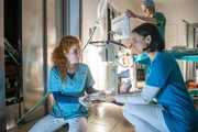 Meike (Sarah Hannemann, l.) und Nora (Mimi Fiedler, r.) versorgen ihre festsitzenden Kollegen im Aufzug mit dem n&ouml;tigen Equipment f&uuml;r eine Not-OP.
