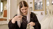 Mit Handstichen wird das Brautkleid finalisiert.