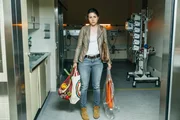 Katrin (Eva Meckbach) steht mit Eink&auml;ufen bepackt vorm OP-Saal, nachdem ihr Mann gerade dort hineingebracht wurde.