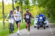 Valentin Poncelet (2.v.l.) und Remigio Quispe (vorne, r.) beim Wings For Life World Run 2024, Breda, Niederlande, am 5. Mai 2024