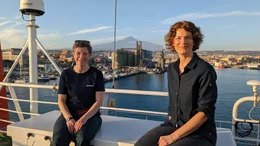 Prof. Dr. Morelia Urlaub (links) und Lena Ganschow auf der Meteor, im Hintergrund der &Auml;tna.