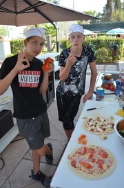 Robin (l.) und Luc (r.) probieren ihre selbst gebackene Pizza.