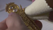 Jeanette Caines poliert goldene Ohrringe.
