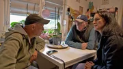 Michael (li.) und Lothar suchen mitten in den Baracken einen Stellplatz f&uuml;r einen Wohnwagen. Und Ella (re.) kennt die Nummer des Mannheimer Kundenservicecenters. Die telefonische Anfrage &uuml;bernimmt Michael aber pers&ouml;nlich.