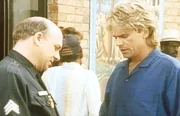 MacGyver (Richard Dean Anderson, r.) berichtet dem Polizisten (John Hostetter, l.), was er bei der Entf&uuml;hrung der Studentin beobachtet hat.