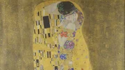 &bdquo;Der Kuss&rdquo; (ca. 1907&ndash;1908) zeigt ein Paar in inniger Umarmung, pr&auml;chtig verziert mit Klimts charakteristischen Farben und Ornamenten.