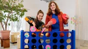Von links: Checkerin Marina mit Entwicklungspsychologin Jeanine Gr&uuml;tter vor einem Vier gewinnt-Spiel.