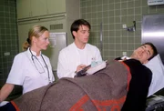 Bonhoff (Wolfgang Krewe, r.) ermittelt getarnt als Patient im Krankenhaus; Dr. Welnik (Jan Sosniok, M.) und Schwester Barbara (Marthe Stanek, l.) untersuchen ihn.