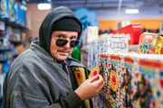 Stefan Steindl (Thomas Mraz) klebt Plastik-Warnkleber auf Spielzeugverpackungen in einem Spielzeuggesch&auml;ft im Einkaufszentrum.
