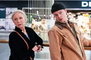 Gerda Schuster (Elfriede Sch&uuml;sseleder) und Alex Peschl (Nikolai Baar-Baarenfels) beobachten Stefan, der im Einkaufszentrum als Aufnahmepr&uuml;fung in die PAK Warnaufkleber auf Spielzeugverpackungen klebt.