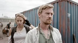 Nikolai (Eric Bouwer) und Elle (Maartje van de Wetering) bem&uuml;hen sich um die Versorgung der Katastrophenopfer im Lager.