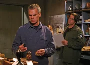 Nach der R&uuml;ckkehr zur Erde katalogisiert Daniel (Michael Shanks, re.) alle mitgebrachten Artefakte, unter denen auch ein sonderbarer Stein ist. Nat&uuml;rlich muss O'Neill (Richard Dean Anderson, li.) sich diesen genauer ansehen...