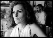 Artemis (Maria Tzivani) sitzt an der Strandbar am Tresen, w&auml;hrend Nasos (Stavros Markalas) Getr&auml;nke macht.