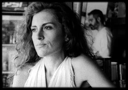 Artemis (Maria Tzivani) sitzt an der Strandbar am Tresen, w&auml;hrend Nasos (Stavros Markalas) Getr&auml;nke macht.