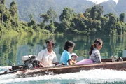 Fischerfamilie f&auml;hrt &uuml;ber den Khao Sok-See zu einer religi&ouml;sen Zeremonie in den Wald.