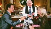 Jeannette (Christine Schuberth) will mit dem gutsituierten Herrn (Andreas Dieck, li.) ansto&szlig;en, den sie f&uuml;r ihr Blind Date "Napoleon" h&auml;lt. Dabei wird sie von dem Kellner (Gunther Philipp) gest&ouml;rt.