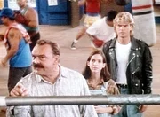 Earl Dent (Dick Butkus, l.) ein ehemaliger Weltklasseboxer, seine Tochter Ronnie (Sarah Koskoff, M.) und MacGyver (Richard Dean Anderson, r.) stehen am Ring und wollen mit Riggins sprechen.