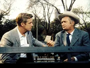 Paul (George Peppard) erf&auml;hrt vom Tierarzt Doc Golightly (Buddy Ebsen) einiges &uuml;ber die Vergangenheit seiner Freundin.