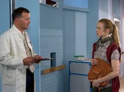 Andrea H&ouml;fler (Anne Kanis) h&ouml;rt sich an, was Dr. Roland Heilmann (Thomas R&uuml;hmann) zum Zustand ihrer Schwester zu sagen hat. Dr. Heilmanns bisherige Untersuchungen deuten darauf hin, dass es sich um einen Herzinfarkt handelt.