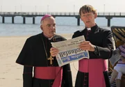 Bischof Hemmelrath (Hans-Michael Rehberg, li.) und Monsignore M&uuml;hlich (Gilbert von Sohlern) erfahren aus der Zeitung, dass Pfarrer Braun wieder "kriminalisiert" hat.