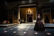 Szene aus &bdquo;Il Gattopardo&ldquo; am Schauspielhaus Z&uuml;rich: In einem weitl&auml;ufigen, klassizistischen Salon mit hohen Portalen begegnen Sophia Mercedes Burtscher als Concetta, in dunkler, volumin&ouml;ser Robe im Vordergrund, und David Rothe als Carlo in Uniform im Hintergrund.