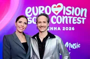 Das Moderationsduo f&uuml;r den 70. Eurovision Song Contest, Victoria Swarovski (l.) und Michael Ostrowski stehen bei einer Pressekonferenz vor dem Logo der Veranstaltung.