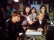 MacGyver (Richard Dean Anderson, 2.v.r.) sieht sich mit Sam (Dalton James, l.) eine Videokassette an, die die Verh&auml;ltnisse in einem chinesischen Straflager dokumentiert.