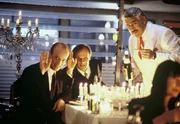 Die Banker Melk (Edgar Selge) und Weich (Christian Berkel) winken ihrem Klienten Oskar Reiter zu. Der Wirt Paolo Rossini (Mario Adorf) verfolgt ungl&auml;ubig die Szenerie.
