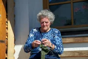 Elenora Eberhart beim Stricken vor ihrem Haus