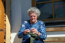 Elenora Eberhart beim Stricken vor ihrem Haus