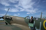 Spitfire Pilot Alex Monk inside of a Spitfire at Biggin Hill Heritage Hangar.