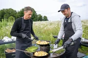 Gastgeber Jochen Kanders (l) und Stefan bereiten das "Land und lecker" -Men&uuml; vor.