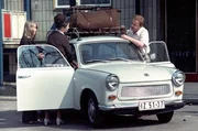 Familie packt auf den Dachgep&auml;cktr&auml;ger ihres Trabant Utensilien f&uuml;r den Urlaub.