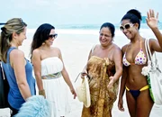 Moderatorin Wasiliki Goutziomitros mit einheimischen Schauspielerinnen: Am Strand von Rio der Janeiro (Copyright SRF)