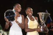 Siegerin Serena Williams (re.) und ihre Schwester und Zweitplatzierte Venus (li.) posieren mit ihren Troph&auml;en nach dem Damenfinale des Compaq Grand Slam Cup 1991 in M&uuml;nchen.