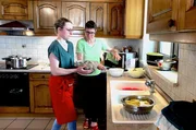 Elena (li.) und Fabienne Buhl (re.) bereiten Fleischkn&ouml;pfle zu.