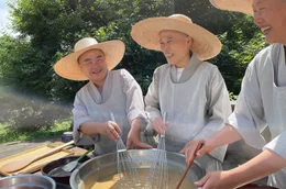Geun Bum Sunim, Yeon il Sunim und Wookwan Sunim (v.l.) bereiten gemeinsam Chilipaste zu.