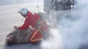 Werksleiter Gruber (Hermann Giefer) liegt nach dem R&uuml;ckstoss durch das Gas verkrampft auf dem Dach. Sanit&auml;ter Ralf Staller (Wolfgang Krewe) leistet erste Hilfe.