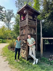 Gartenexpertin Theresa und Robert vor einem Nützlingsturm.