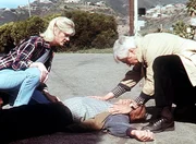 Steve (Barry Van Dyke, liegend) ist von einem flüchtenden Gangster angefahren worden. Dr. Mark Sloan (Dick Van Dyke, r.) und Carol (Stacy Van Dyke) leisten erste Hilfe. Steve (Barry Van Dyke, liegend) ist von einem flüchtenden Gangster angefahren worden. Dr. Mark Sloan (Dick Van Dyke, r.) und Carol (Stacy Van Dyke) leisten erste Hilfe.