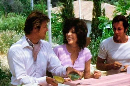 Joan Collins (Mi.) mit Roger Moore (li.) und Tony Curtis (re.) im Jahr 1971